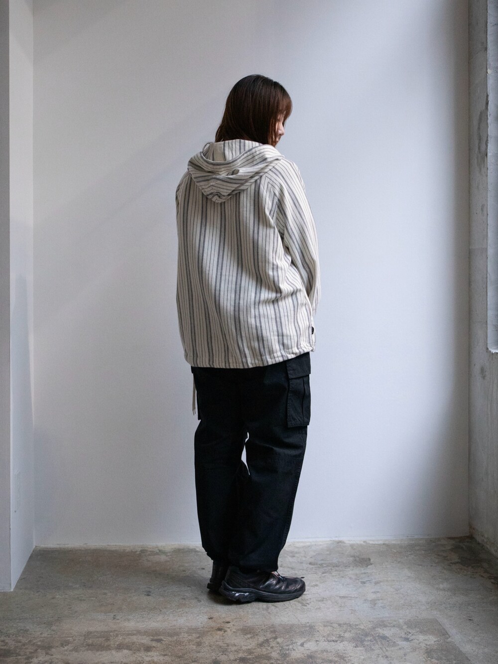 ホワイト系のパーカー、ブラック系のカーゴパンツを着用したレディースの春コーディネートの2枚目の写真