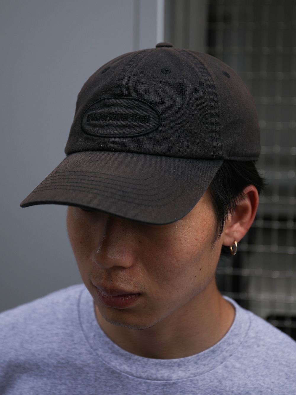 グレー系のTシャツ/カットソー、ブルー系のデニムパンツ、ブラック系のキャップを着用したメンズの夏コーディネートの4枚目の写真