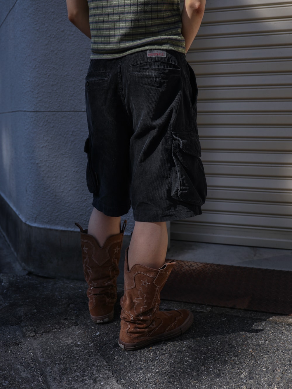 グリーン系のキャミソール、ブラック系のカーゴパンツ、ホワイト系のTシャツ/カットソーを着用したレディースの春コーディネートの3枚目の写真