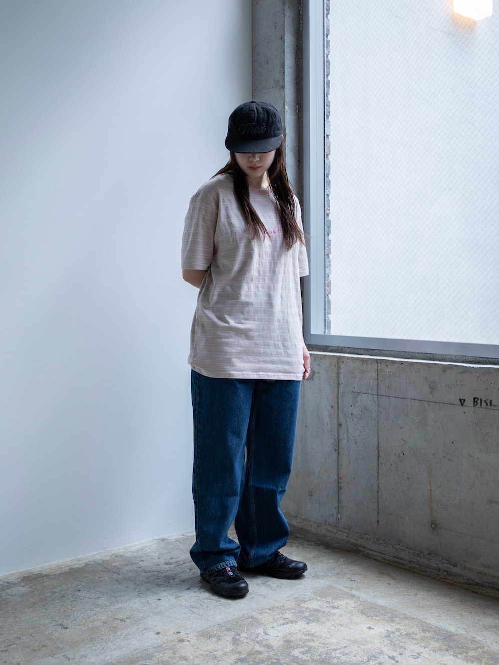 ピンク系のTシャツ/カットソー、ブルー系のデニムパンツ、ブラック系のキャップを着用したレディースの春コーディネートの2枚目の写真