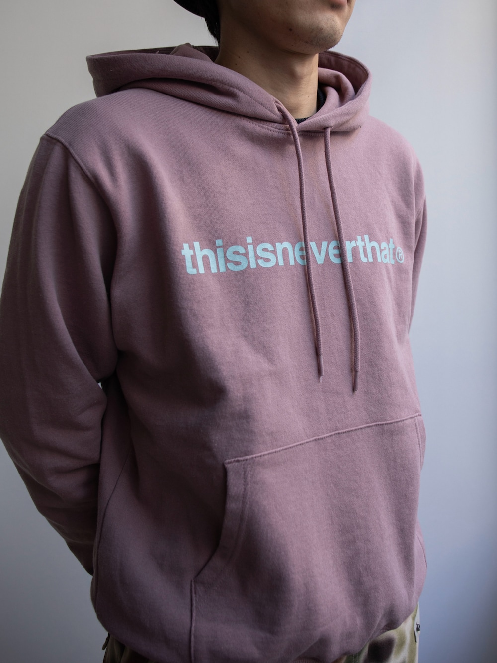 ピンク系のパーカー、その他のカーゴパンツ、グレー系のハットを着用したメンズの冬コーディネートの2枚目の写真