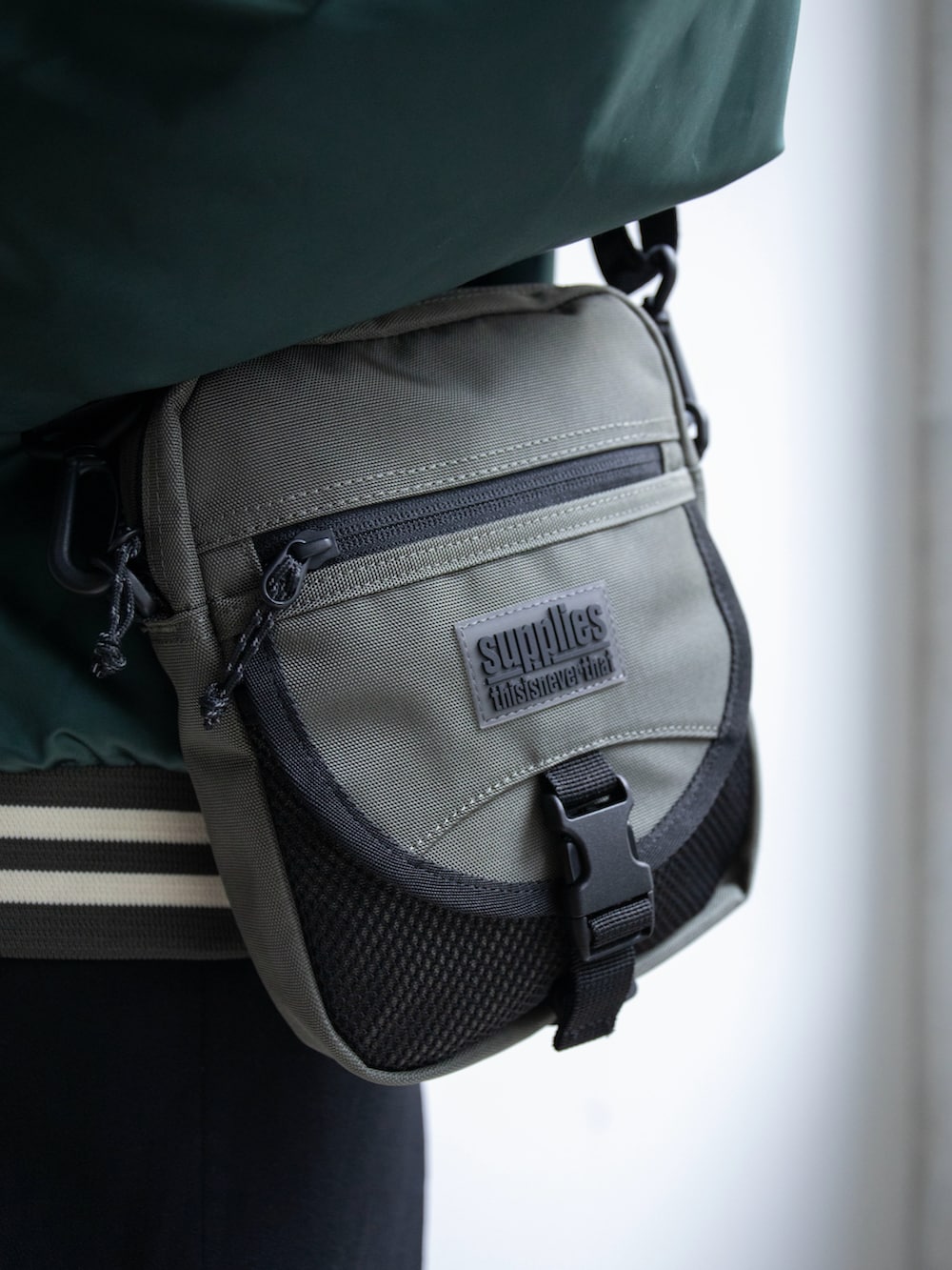 グリーン系のブルゾン、グリーン系のショルダーバッグ、ピンク系のニットキャップ/ビーニーを着用したレディースの春コーディネートの4枚目の写真