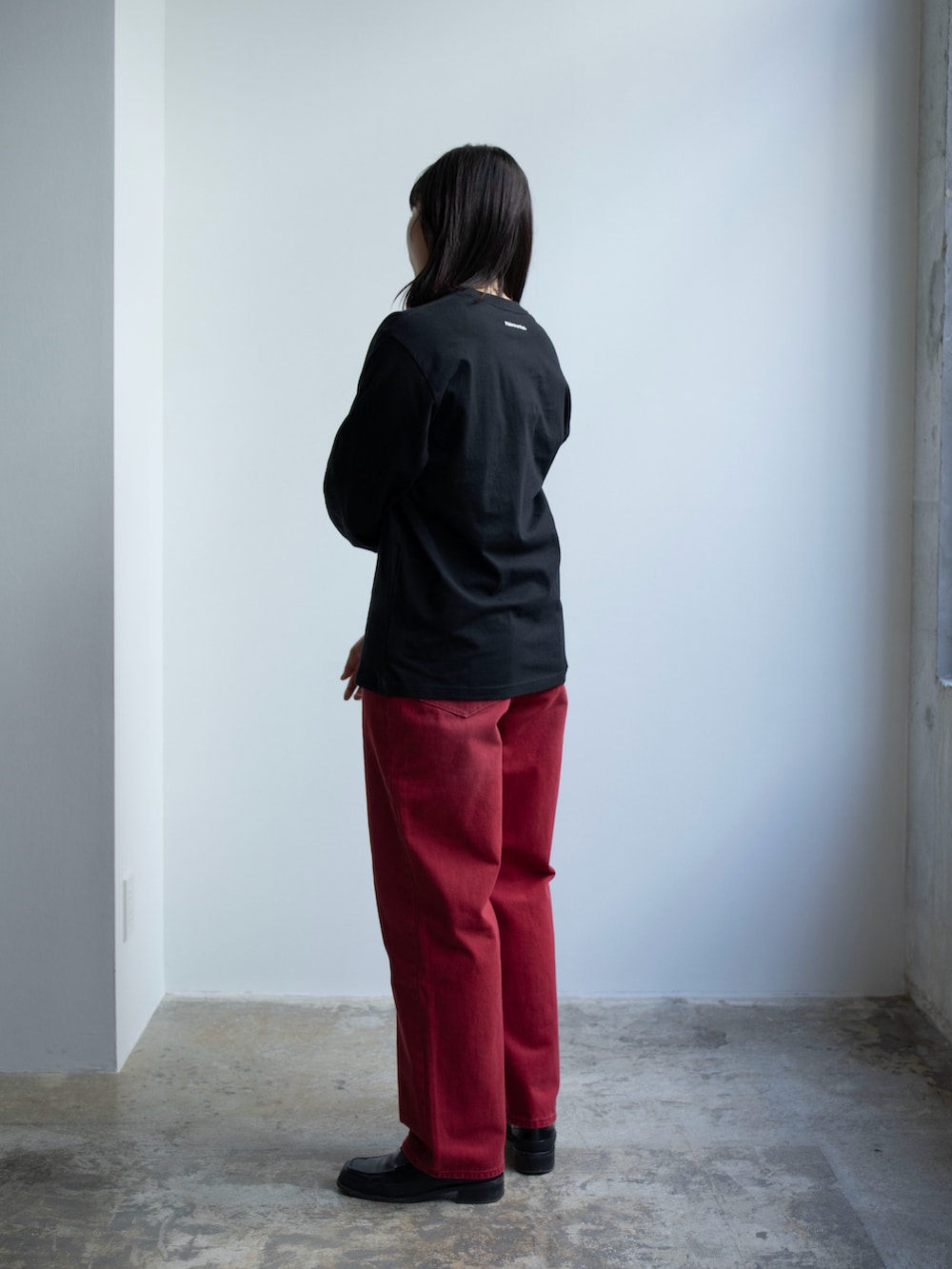 レッド系のデニムパンツ、ブラック系のTシャツ/カットソーを着用したレディースの春コーディネートの2枚目の写真