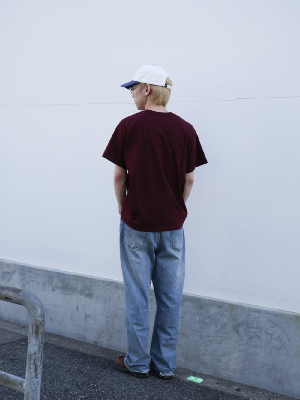 ブルー系のデニムパンツ、レッド系のTシャツ/カットソー、ホワイト系のキャップを着用したメンズの夏コーディネートの6枚目の写真