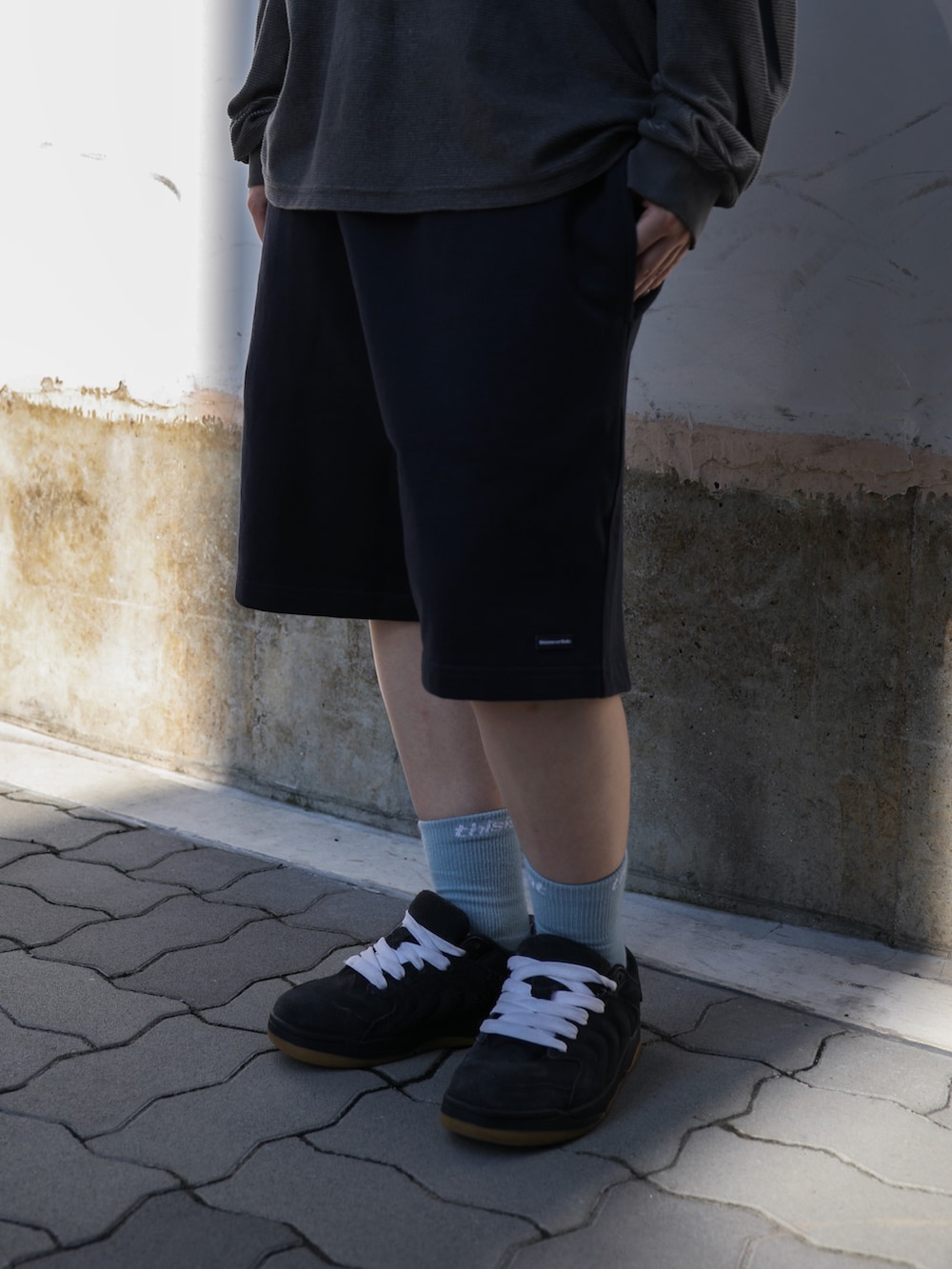 グレー系のTシャツ/カットソー、ブルー系のスウェットパンツ、レッド系のキャップを着用したレディースの夏コーディネートの5枚目の写真