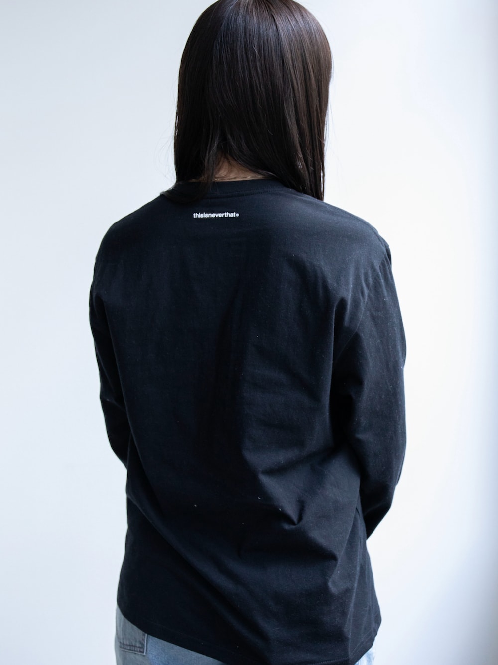 ブラック系のTシャツ/カットソー、ブルー系のデニムパンツを着用したレディースの春コーディネートの3枚目の写真