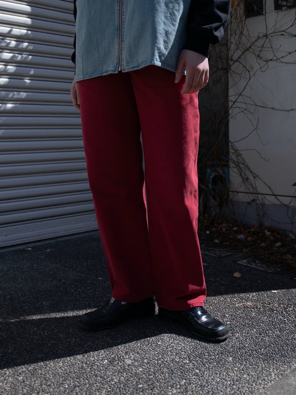 レッド系のデニムパンツ、ブルー系のシャツ/ブラウス、ブラック系のTシャツ/カットソーを着用したレディースの春コーディネートの4枚目の写真