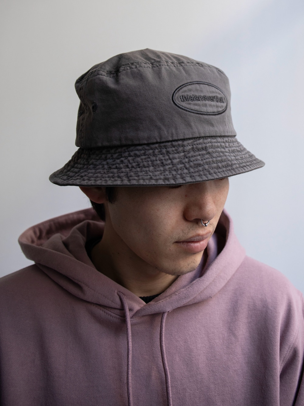 ピンク系のパーカー、その他のカーゴパンツ、グレー系のハットを着用したメンズの冬コーディネートの3枚目の写真