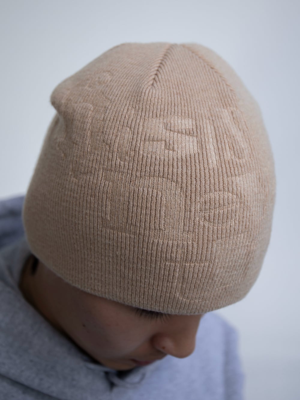 グレー系のパーカー、ブルー系のデニムパンツ、ベージュ系のニットキャップ/ビーニーを着用したメンズの冬コーディネートの3枚目の写真