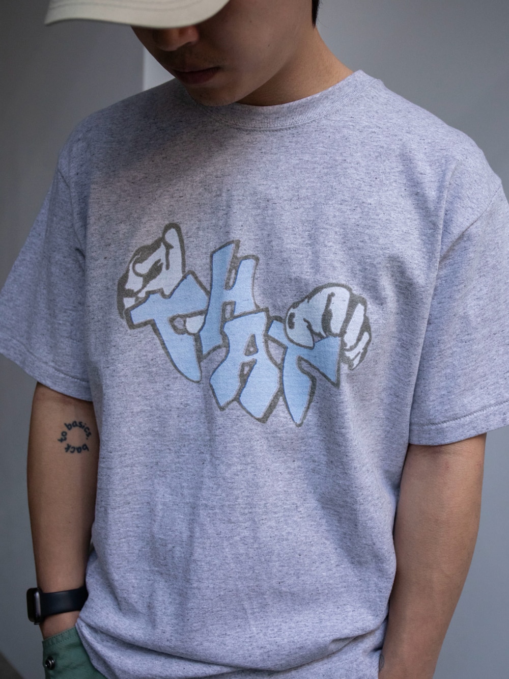 グレー系のTシャツ/カットソー、グリーン系のカーゴパンツ、ベージュ系のキャップを着用したメンズの春コーディネートの2枚目の写真