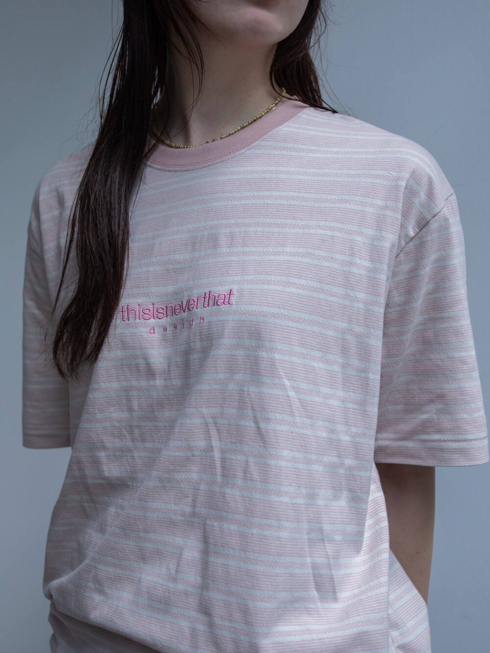 ピンク系のTシャツ/カットソー、ブルー系のデニムパンツ、ブラック系のキャップを着用したレディースの春コーディネートの4枚目の写真