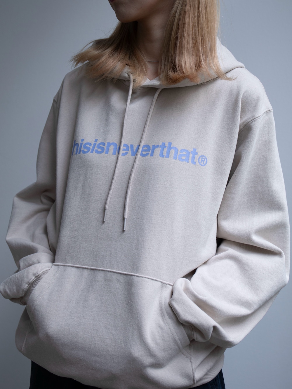 ベージュ系のパーカー、ブルー系のその他パンツを着用したレディースの春コーディネートの3枚目の写真