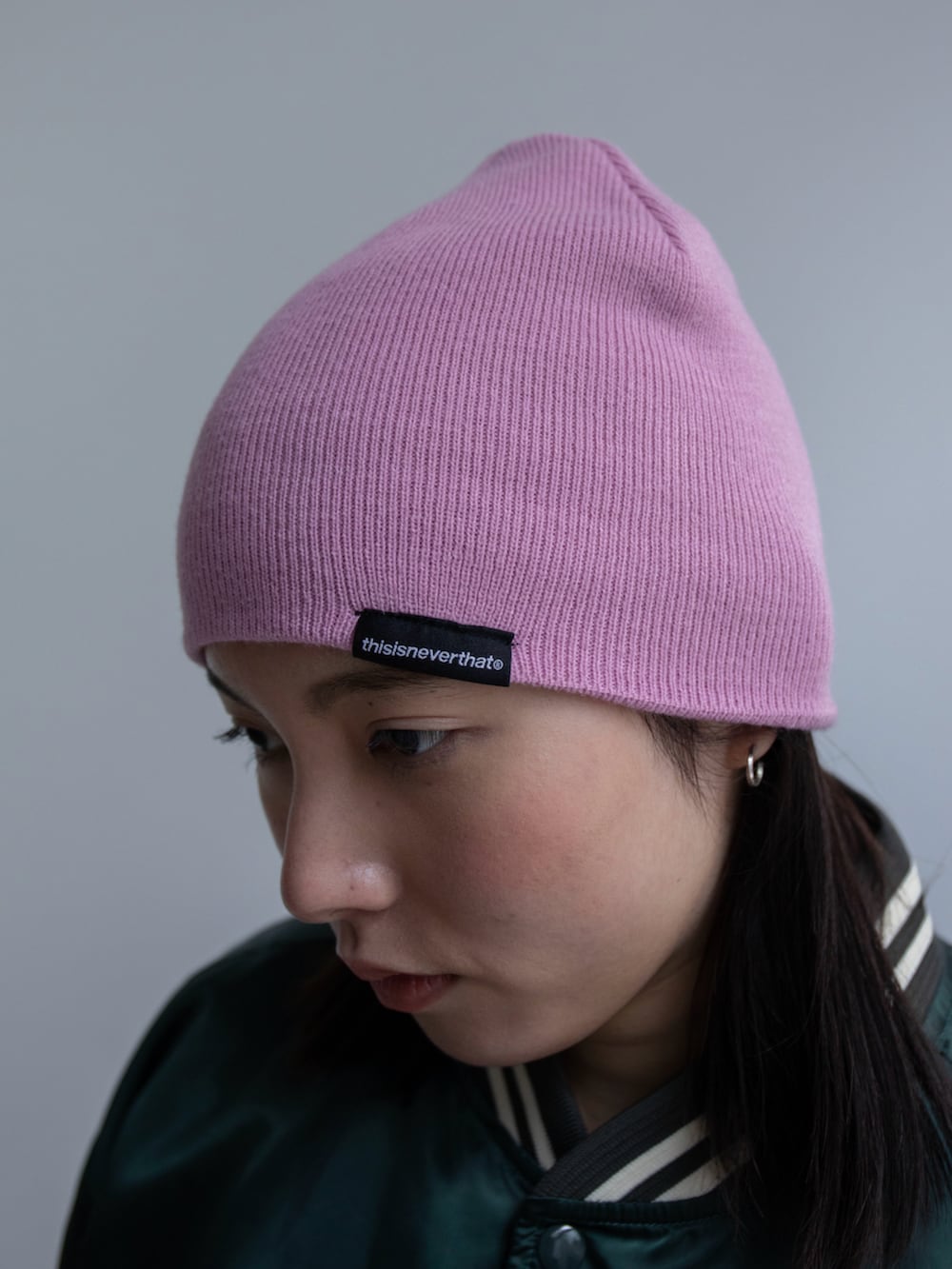 グリーン系のブルゾン、グリーン系のショルダーバッグ、ピンク系のニットキャップ/ビーニーを着用したレディースの春コーディネートの5枚目の写真