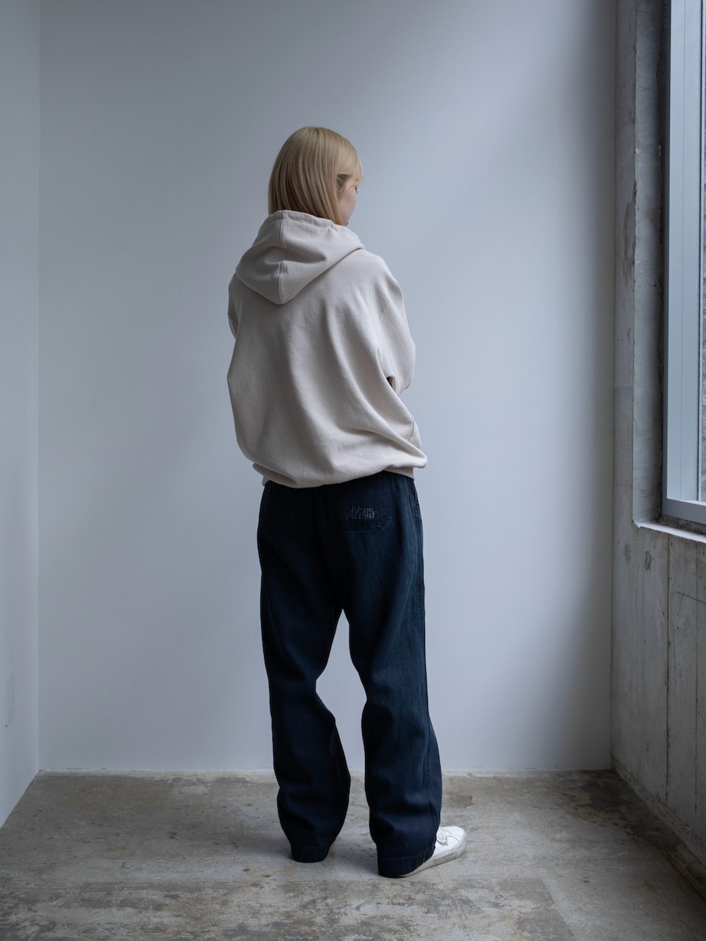 ベージュ系のパーカー、ブルー系のその他パンツを着用したレディースの春コーディネートの2枚目の写真