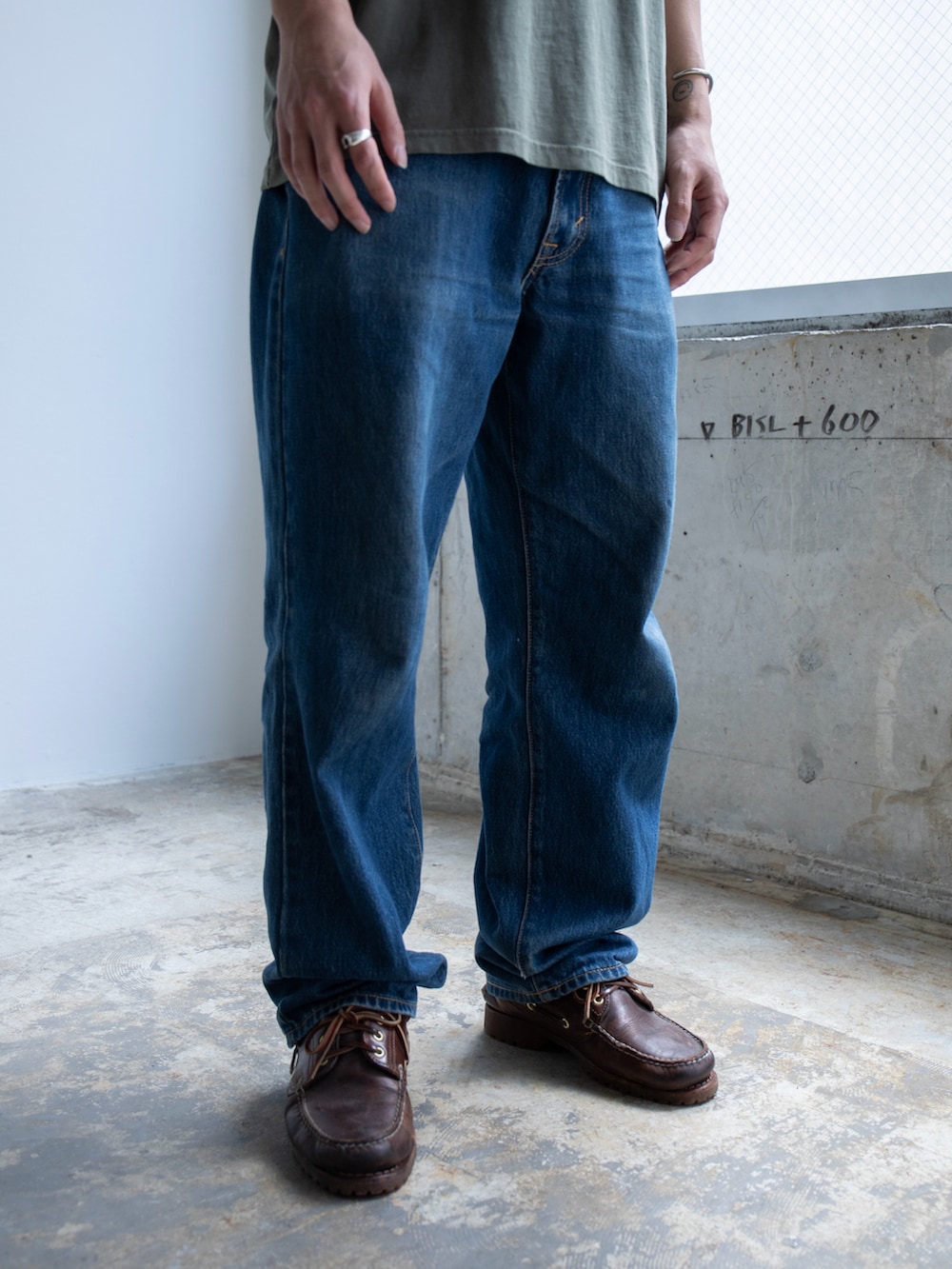 グリーン系のTシャツ/カットソー、ブルー系のデニムパンツを着用したメンズの春コーディネートの5枚目の写真