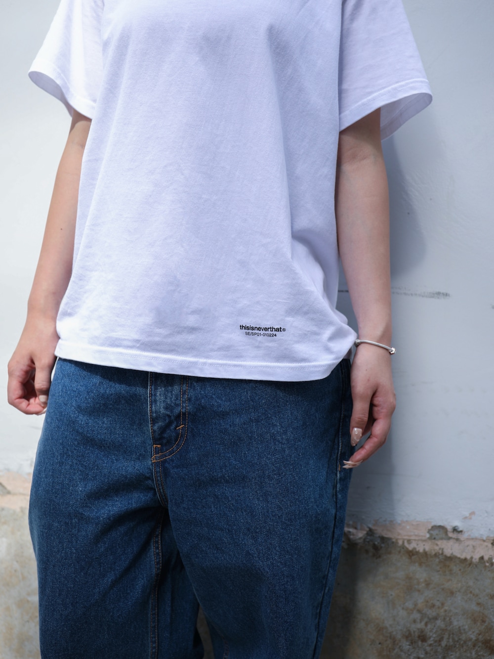 ブルー系のデニムパンツ、ホワイト系のTシャツ/カットソー、ブラック系のニットキャップ/ビーニーを着用したレディースの夏コーディネートの3枚目の写真