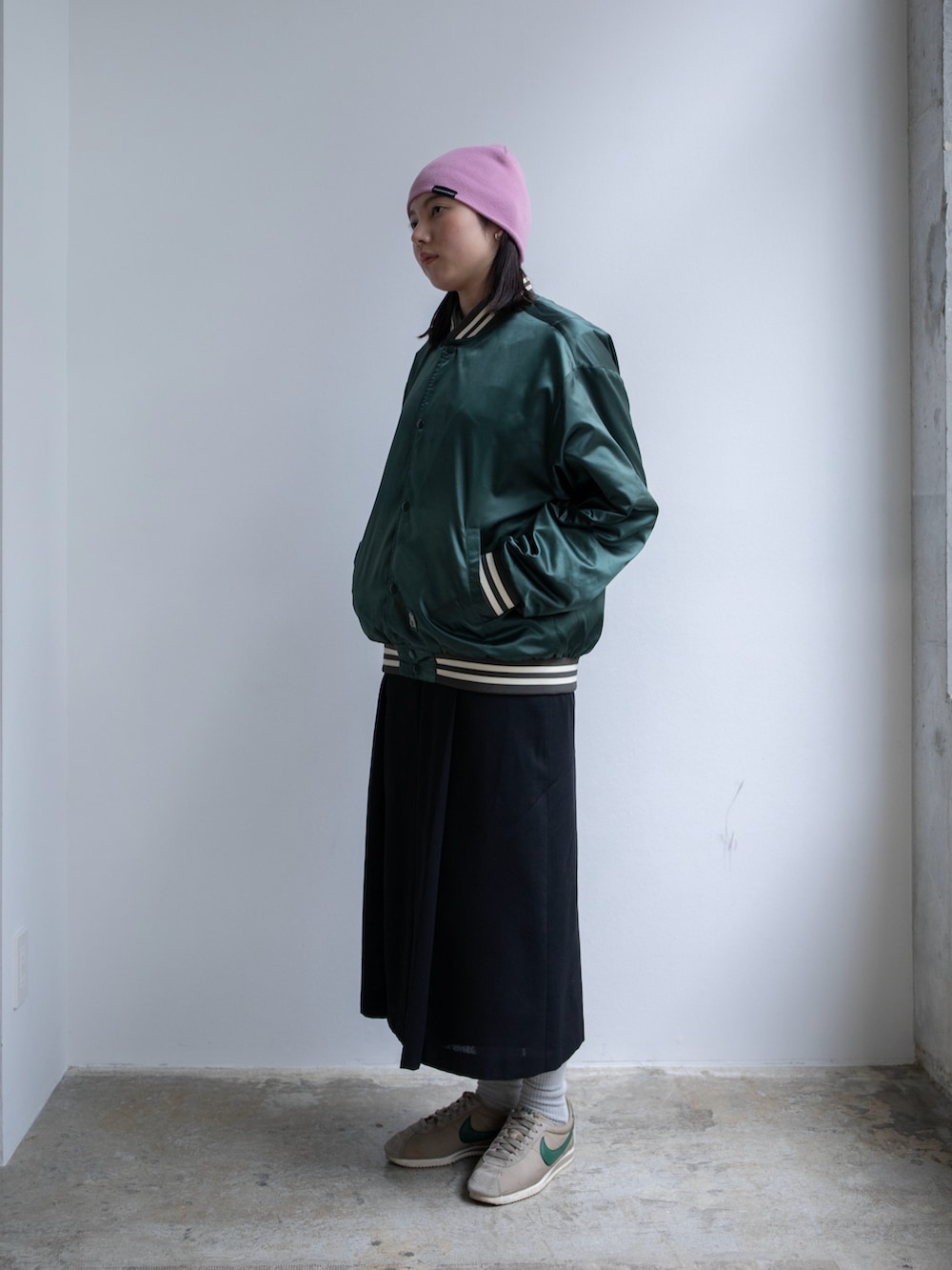 グリーン系のブルゾン、グリーン系のショルダーバッグ、ピンク系のニットキャップ/ビーニーを着用したレディースの春コーディネートの2枚目の写真