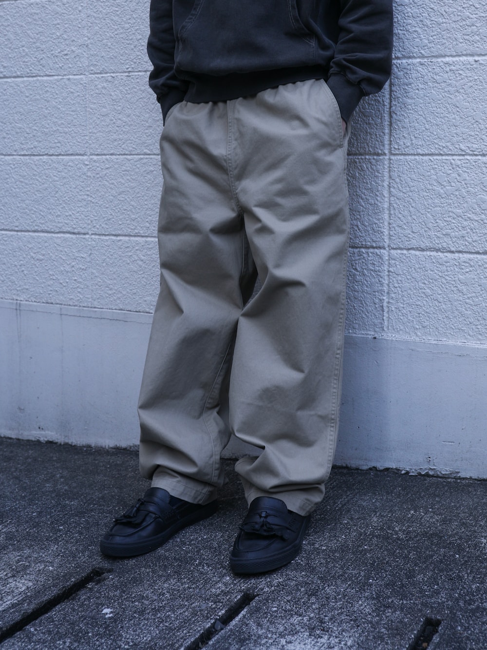 グレー系のパーカー、ベージュ系のその他パンツを着用したメンズの春コーディネートの3枚目の写真