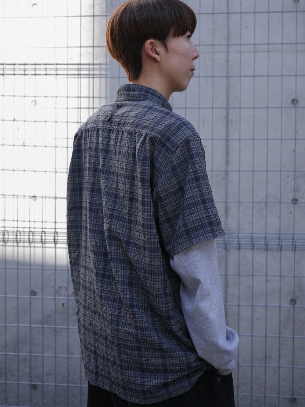 グレー系のTシャツ/カットソー、ブルー系のシャツ/ブラウス、ブラック系のデニムパンツを着用したメンズの春コーディネートの4枚目の写真