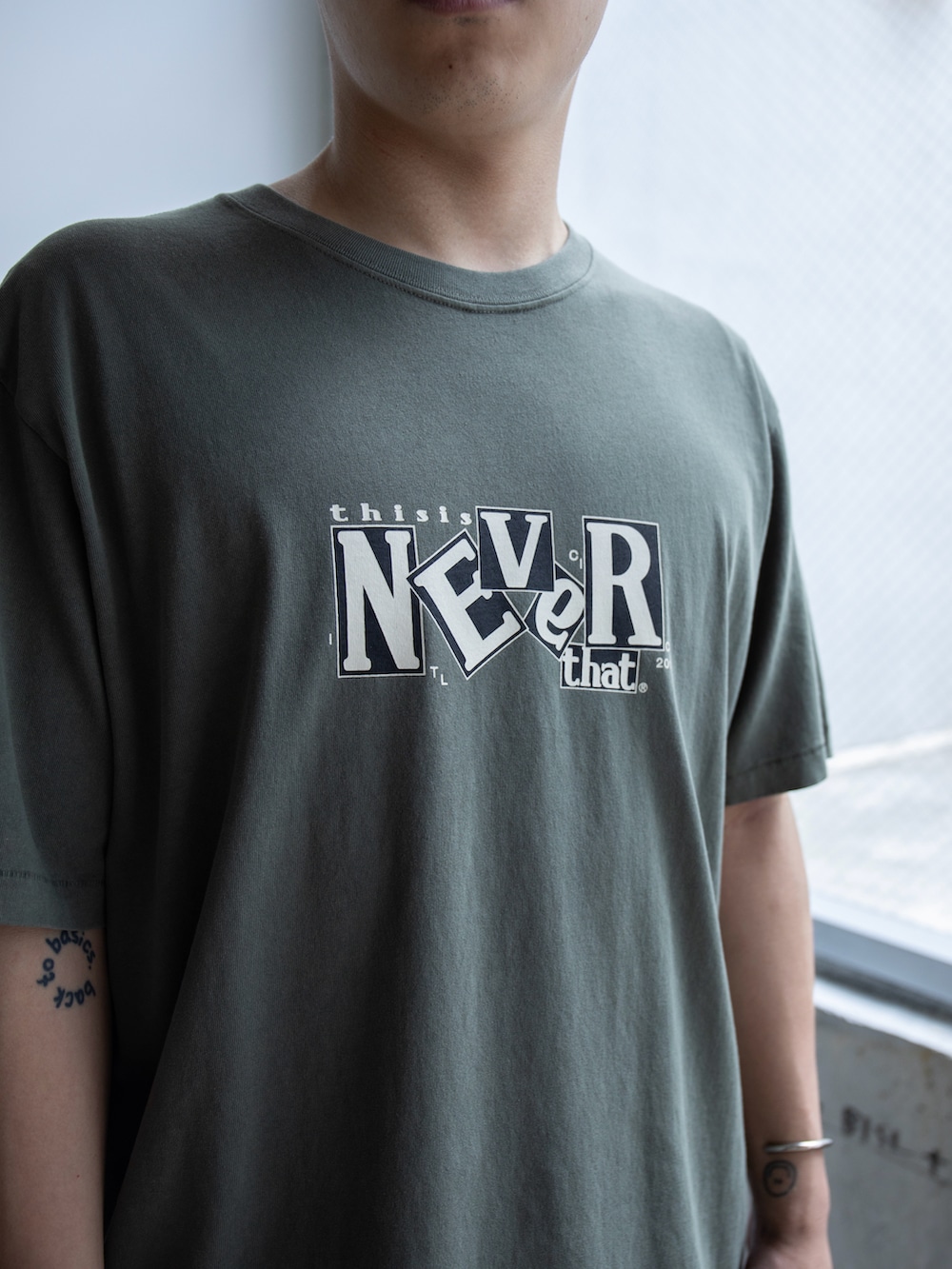 グリーン系のTシャツ/カットソー、ブルー系のデニムパンツを着用したメンズの春コーディネートの3枚目の写真