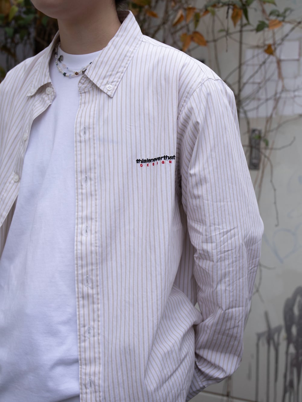 ホワイト系のTシャツ/カットソー、ベージュ系のシャツ/ブラウス、ブルー系のデニムパンツを着用したレディースの春コーディネートの2枚目の写真