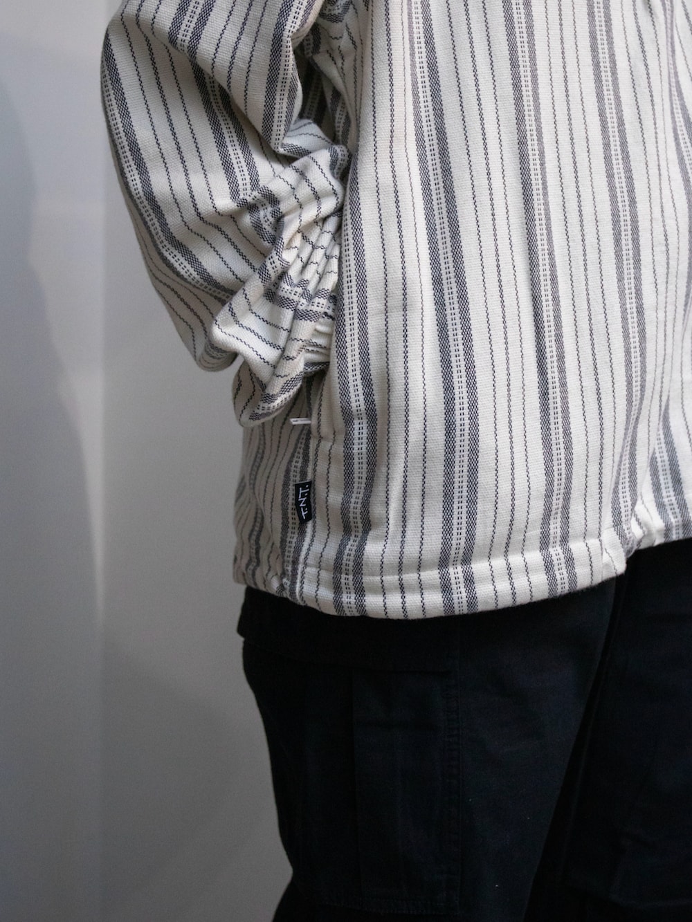 ホワイト系のパーカー、ブラック系のカーゴパンツを着用したレディースの春コーディネートの3枚目の写真