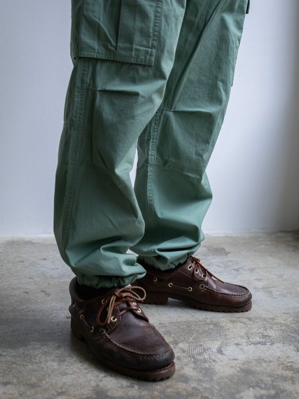 グレー系のTシャツ/カットソー、グリーン系のカーゴパンツ、ベージュ系のキャップを着用したメンズの春コーディネートの4枚目の写真