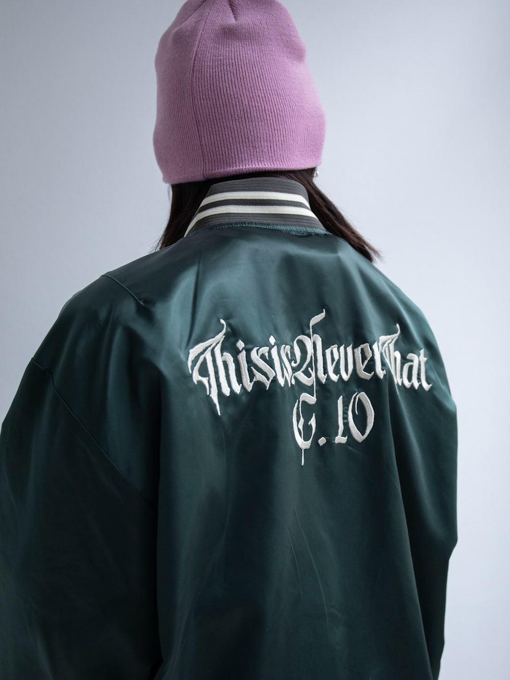 グリーン系のブルゾン、グリーン系のショルダーバッグ、ピンク系のニットキャップ/ビーニーを着用したレディースの春コーディネートの3枚目の写真