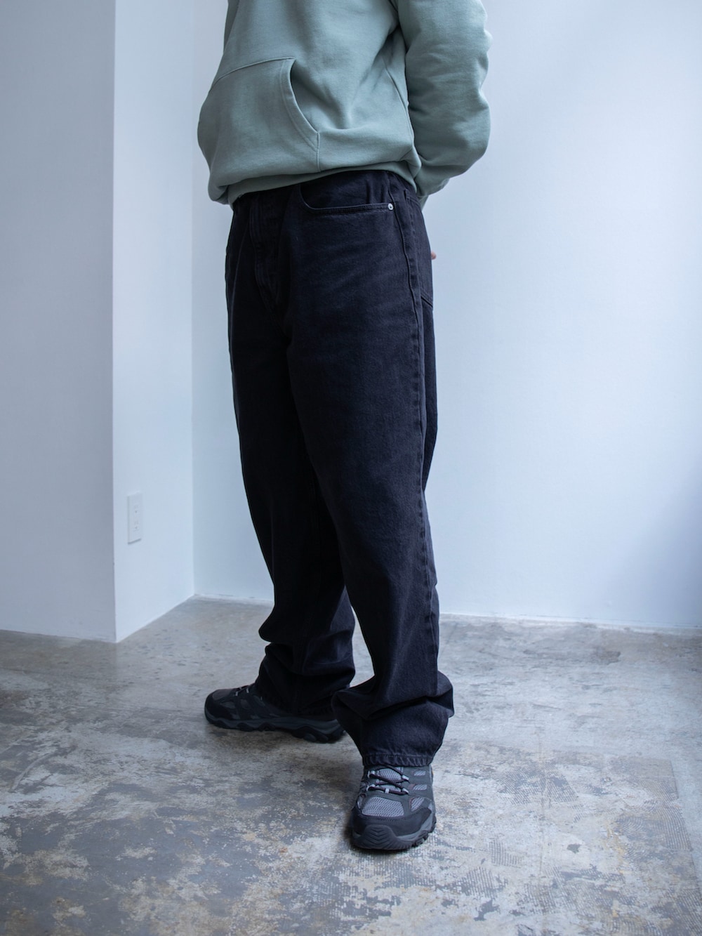 グリーン系のパーカー、ブラック系のデニムパンツを着用したメンズの春コーディネートの4枚目の写真