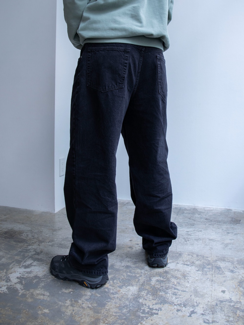 グリーン系のパーカー、ブラック系のデニムパンツを着用したメンズの春コーディネートの5枚目の写真