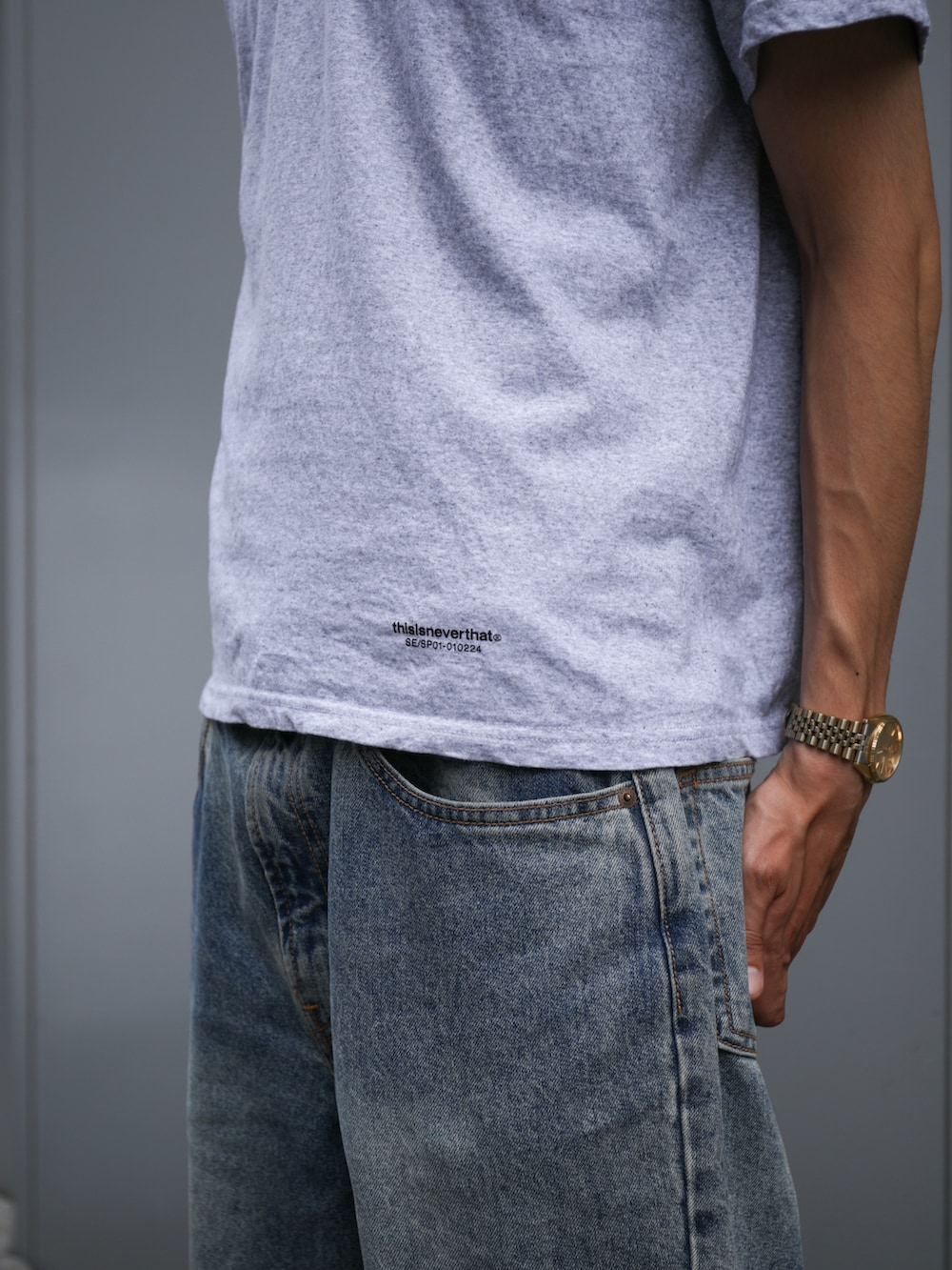 グレー系のTシャツ/カットソー、ブルー系のデニムパンツ、ブラック系のキャップを着用したメンズの夏コーディネートの3枚目の写真