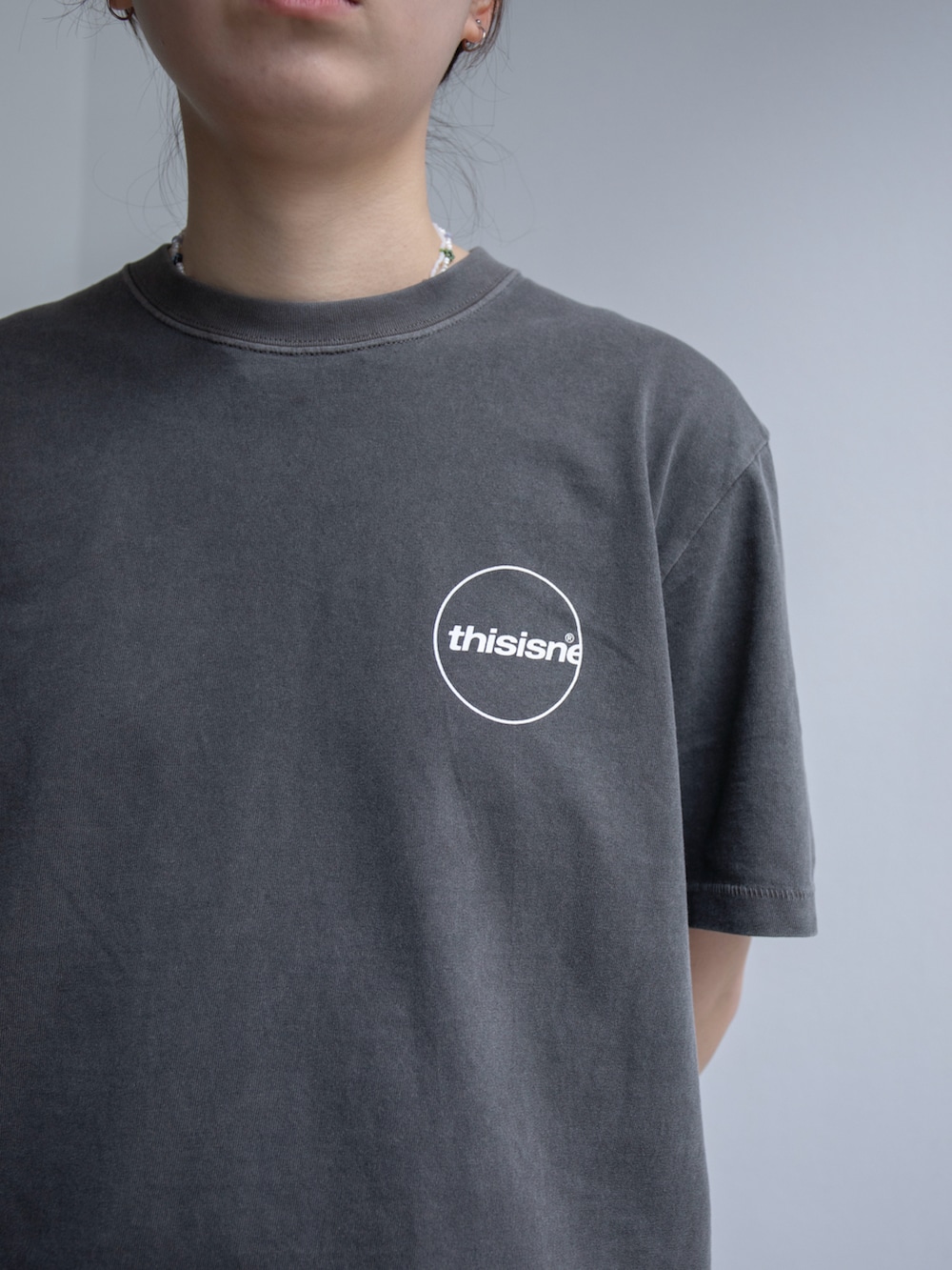 グレー系のTシャツ/カットソー、ブラック系のカーゴパンツを着用したレディースの春コーディネートの3枚目の写真