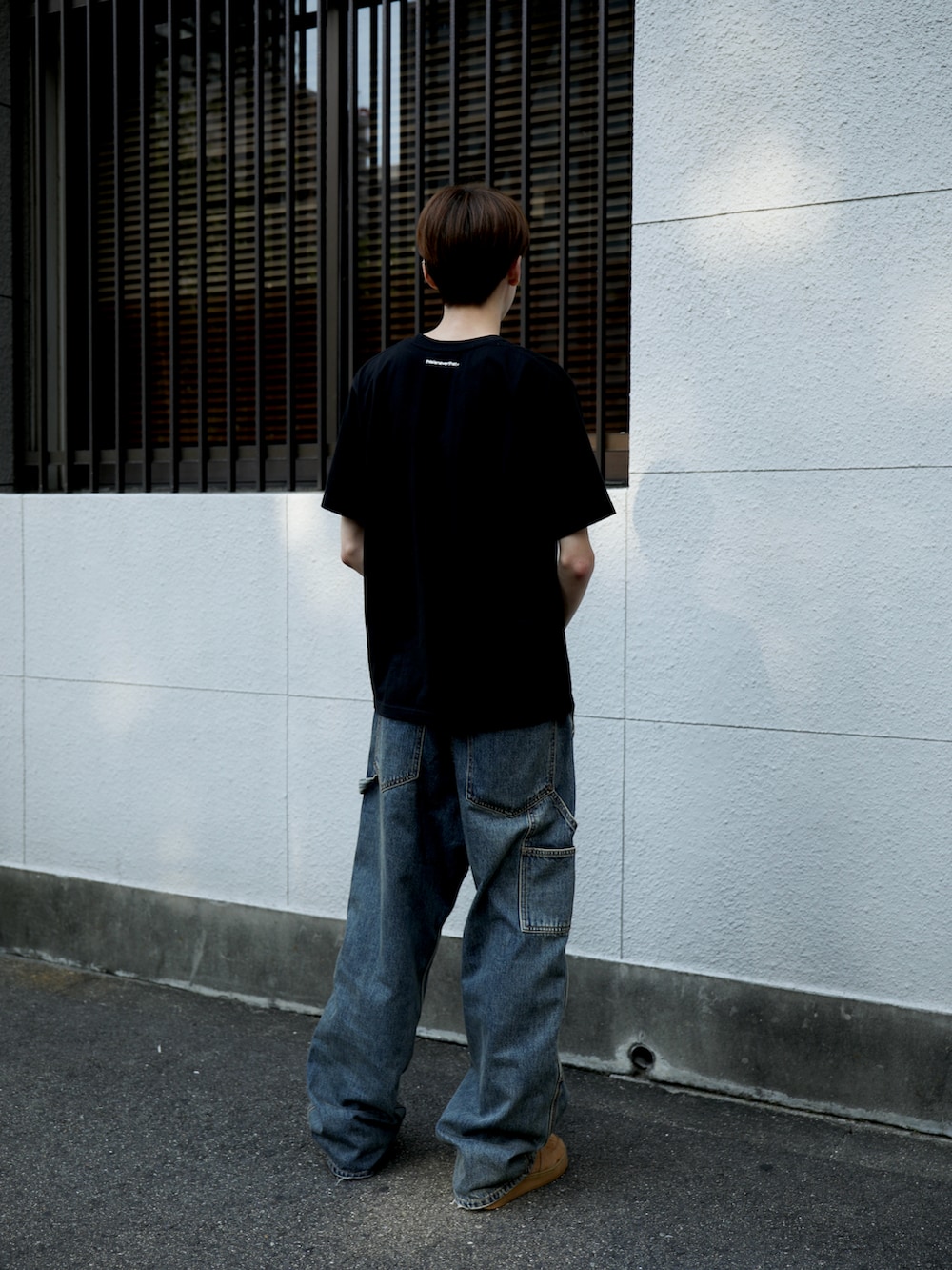ブラック系のTシャツ/カットソー、グレー系のデニムパンツを着用したメンズの夏コーディネートの3枚目の写真