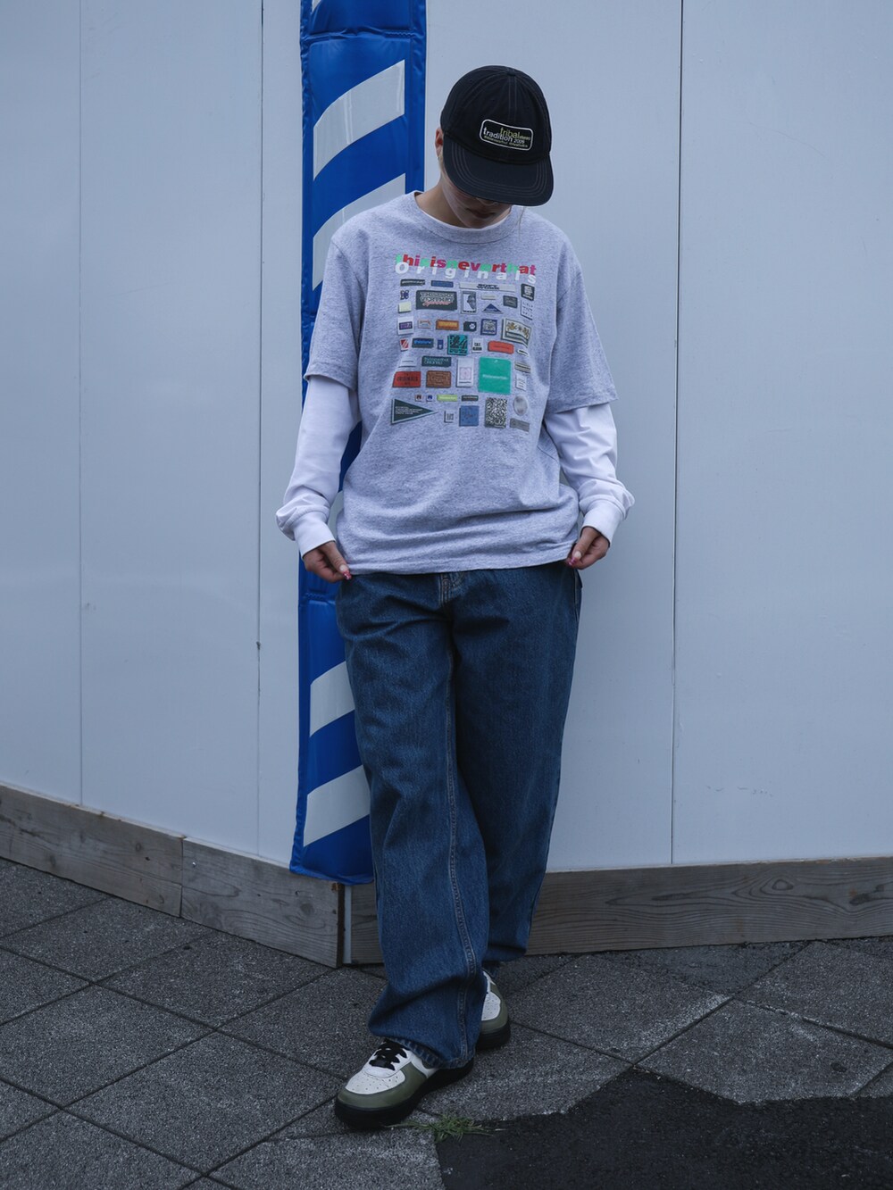 グレー系のTシャツ/カットソー、ブルー系のデニムパンツ、ブルー系のキャップを着用したレディースの春コーディネートの2枚目の写真