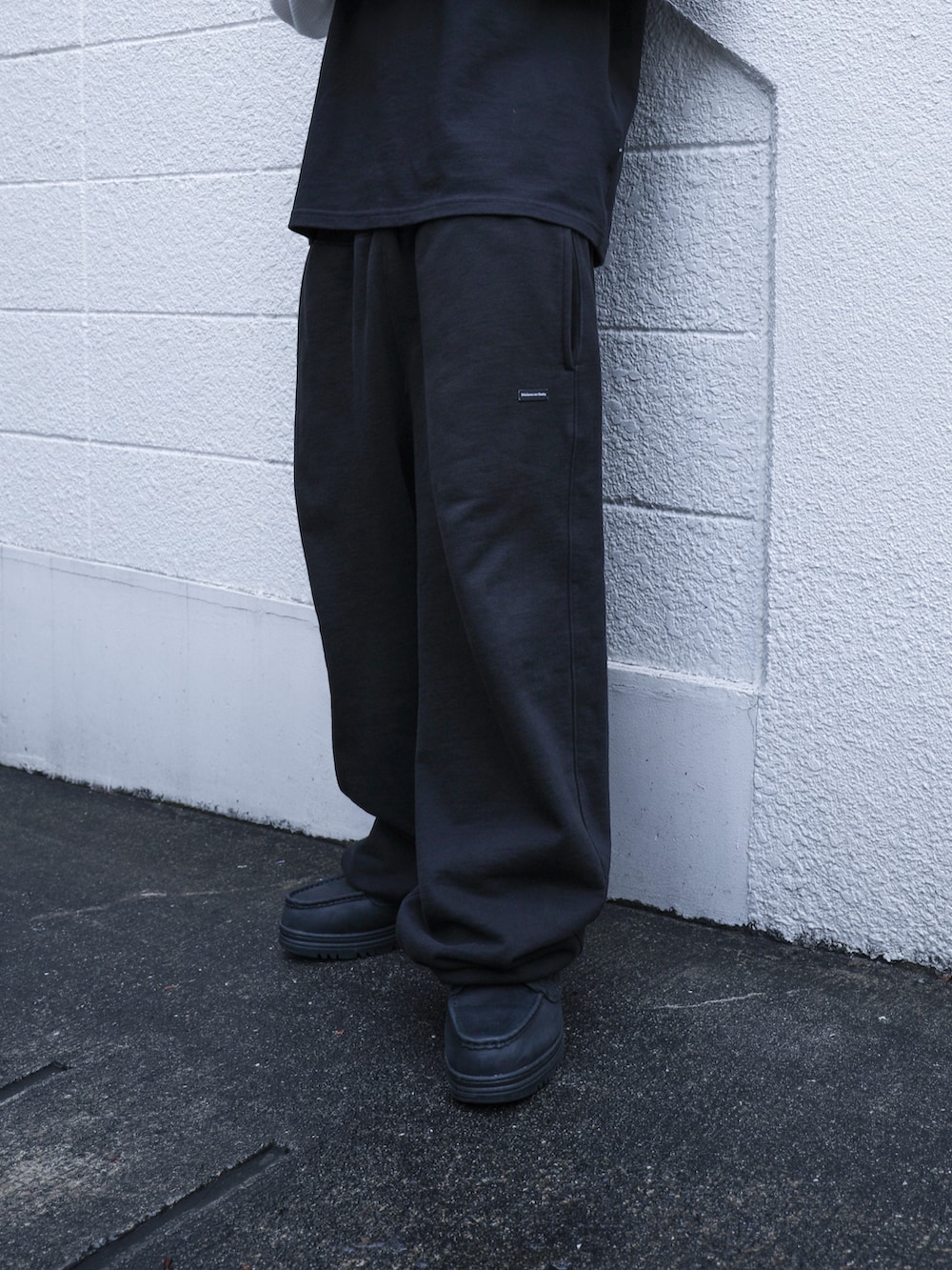 ブラック系のTシャツ/カットソー、ブラック系のスウェットパンツを着用したメンズの春コーディネートの3枚目の写真