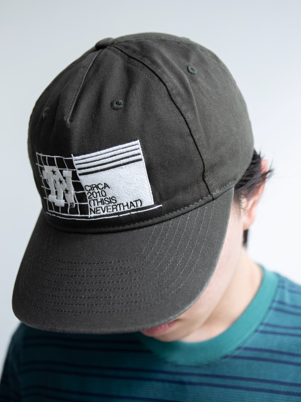 ブラック系のデニムパンツ、ブルー系のTシャツ/カットソー、グリーン系のキャップを着用したメンズの春コーディネートの3枚目の写真