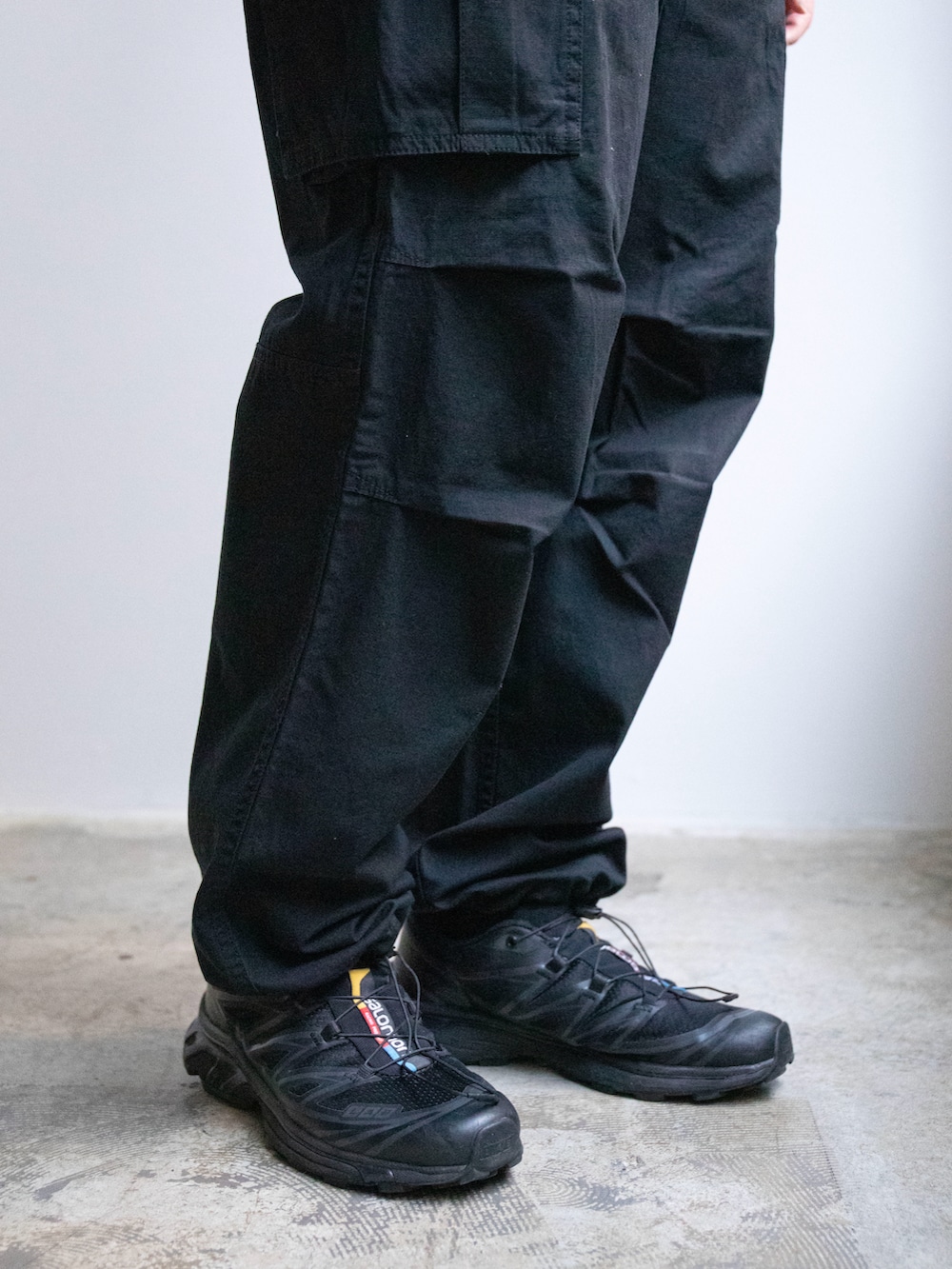 ホワイト系のパーカー、ブラック系のカーゴパンツを着用したレディースの春コーディネートの4枚目の写真