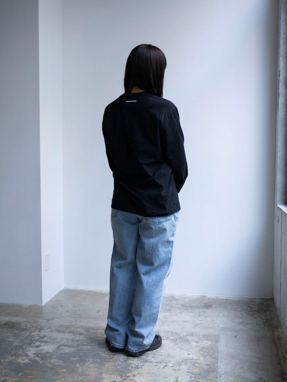 ブラック系のTシャツ/カットソー、ブルー系のデニムパンツを着用したレディースの春コーディネートの2枚目の写真