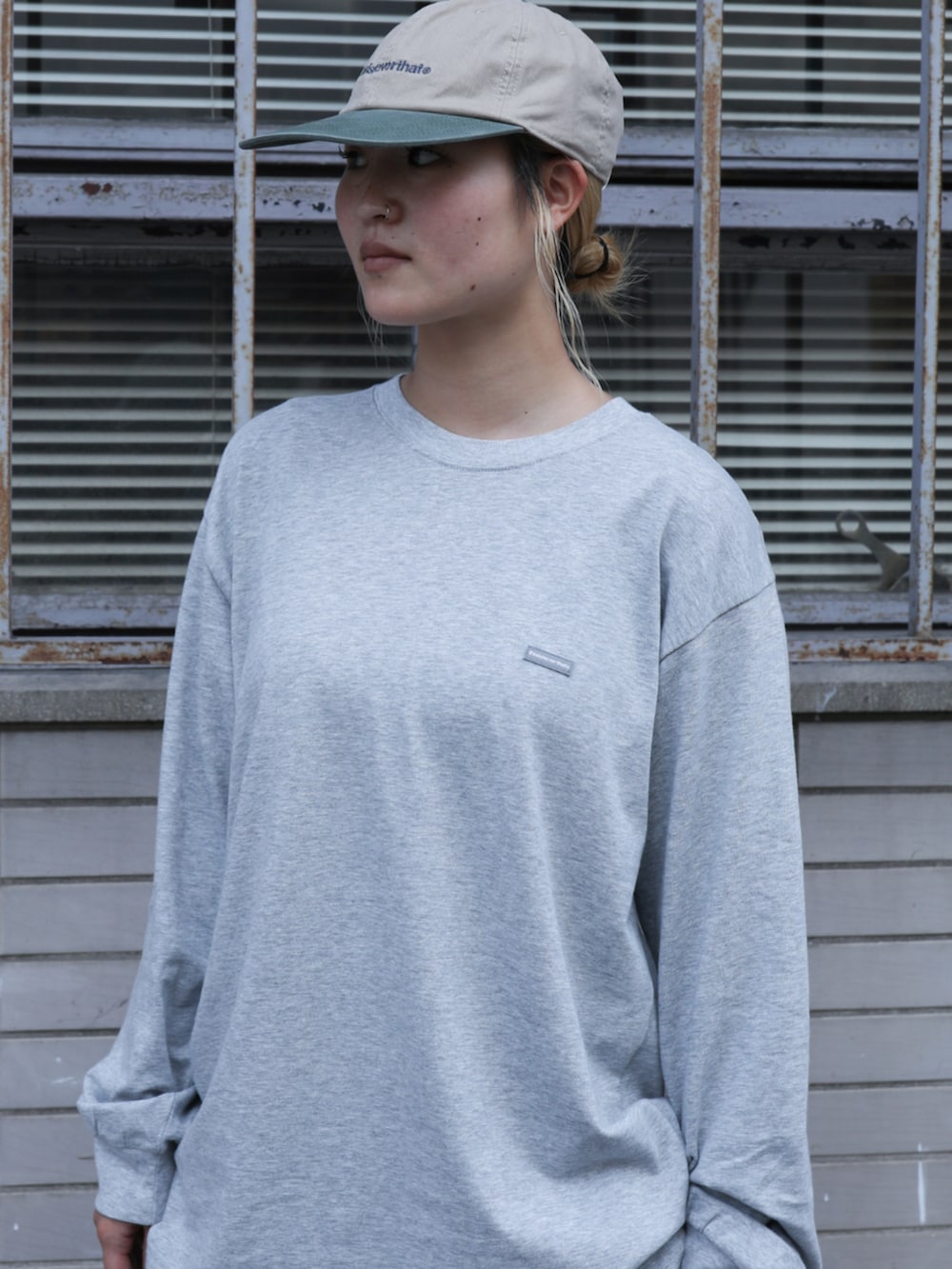 グレー系のTシャツ/カットソー、ブルー系のその他パンツ、ベージュ系のキャップを着用したレディースの夏コーディネートの2枚目の写真