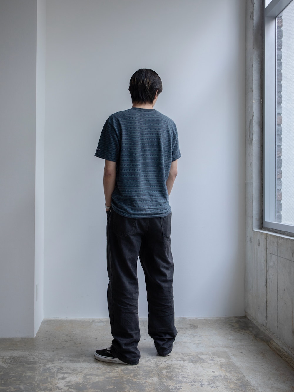 ブルー系のTシャツ/カットソー、ブラック系のデニムパンツを着用したメンズの春コーディネートの3枚目の写真