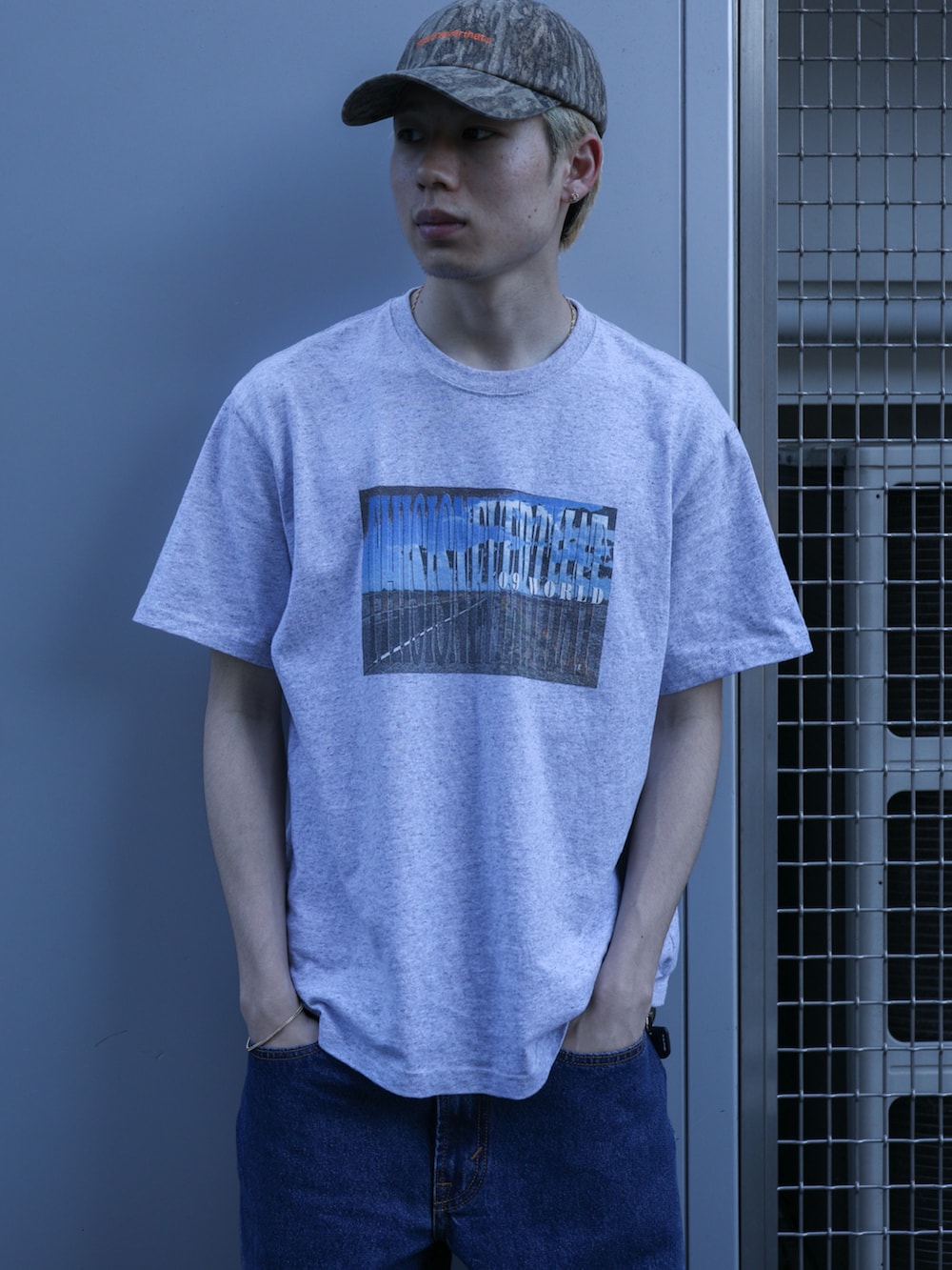 グレー系のTシャツ/カットソー、ブルー系のデニムパンツ、その他のキャップを着用したメンズの春コーディネートの2枚目の写真