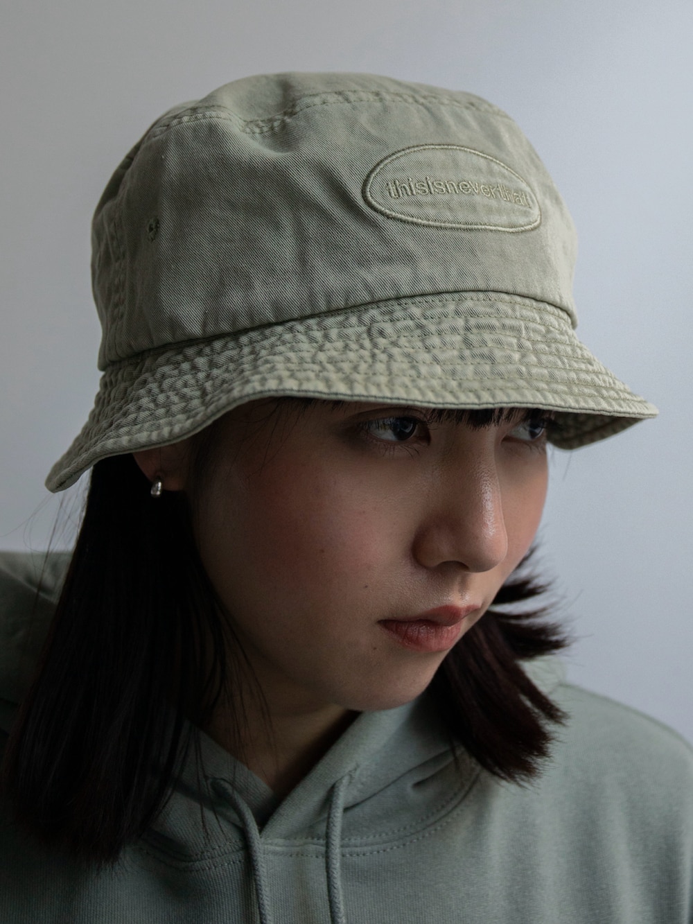 グリーン系のパーカー、ブルー系のその他パンツ、グリーン系のハットを着用したレディースの冬コーディネートの3枚目の写真