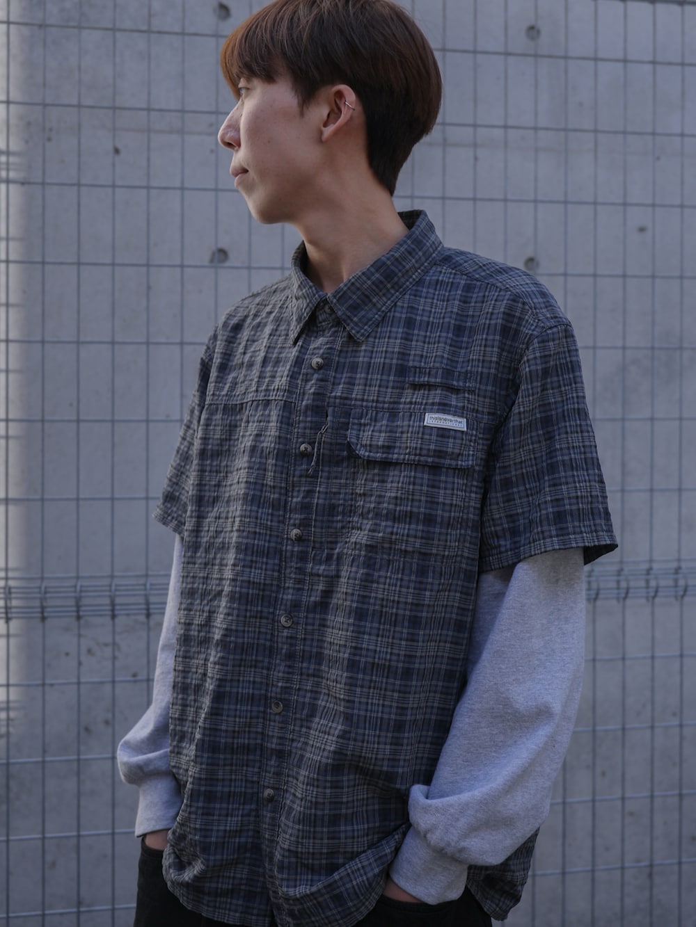 グレー系のTシャツ/カットソー、ブルー系のシャツ/ブラウス、ブラック系のデニムパンツを着用したメンズの春コーディネートの2枚目の写真