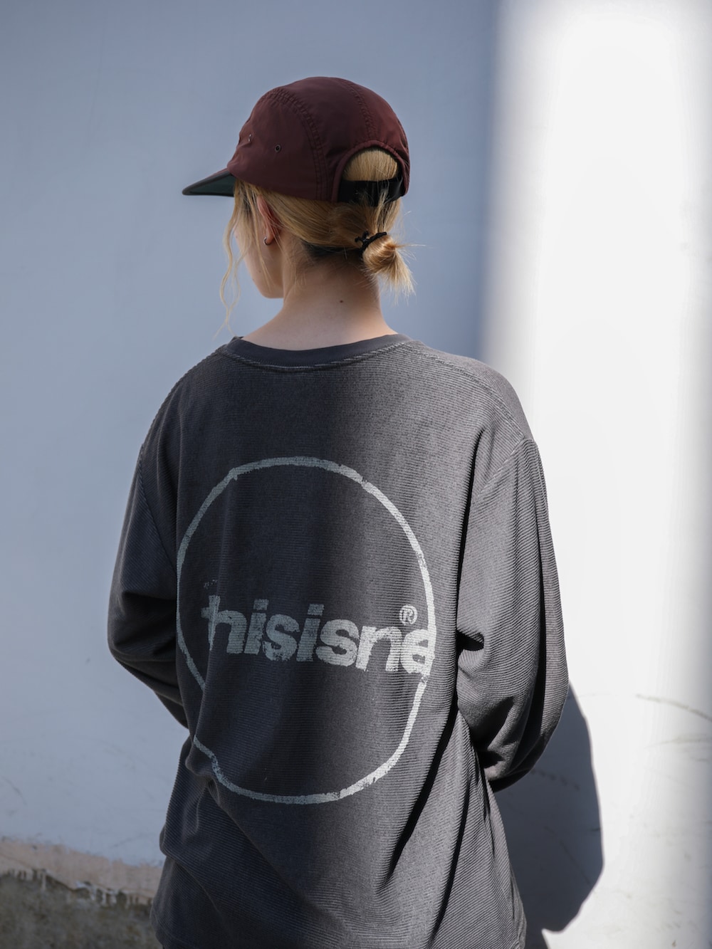 グレー系のTシャツ/カットソー、ブルー系のスウェットパンツ、レッド系のキャップを着用したレディースの夏コーディネートの2枚目の写真