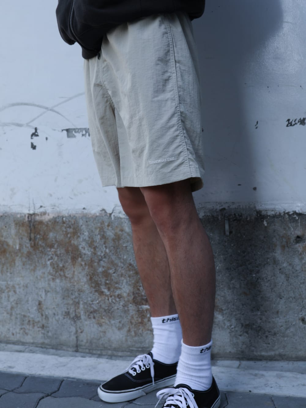 ブラック系のパーカー、ベージュ系のその他パンツ、ブルー系のキャップを着用したメンズの夏コーディネートの4枚目の写真