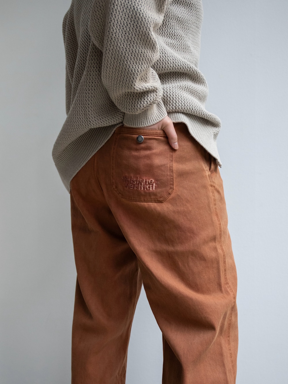 オレンジ系のその他パンツ、ベージュ系のカーディガン/ボレロを着用したレディースの冬コーディネートの3枚目の写真