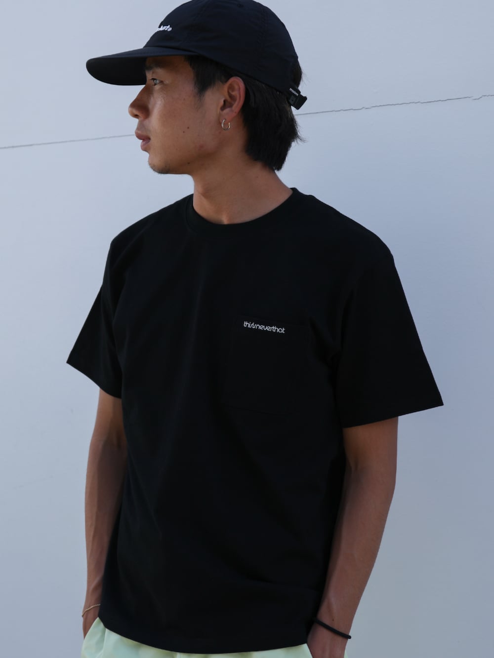 ブラック系のTシャツ/カットソー、イエロー系のその他パンツ、ブラック系のキャップを着用したメンズの夏コーディネートの2枚目の写真
