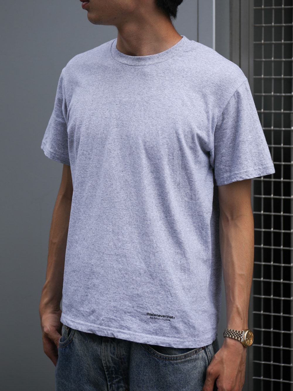 グレー系のTシャツ/カットソー、ブルー系のデニムパンツ、ブラック系のキャップを着用したメンズの夏コーディネートの2枚目の写真
