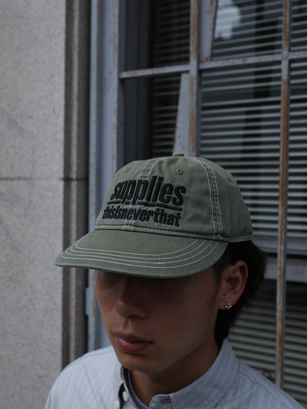 ブルー系のデニムパンツ、グレー系のシャツ/ブラウス、グリーン系のキャップを着用したメンズの夏コーディネートの5枚目の写真