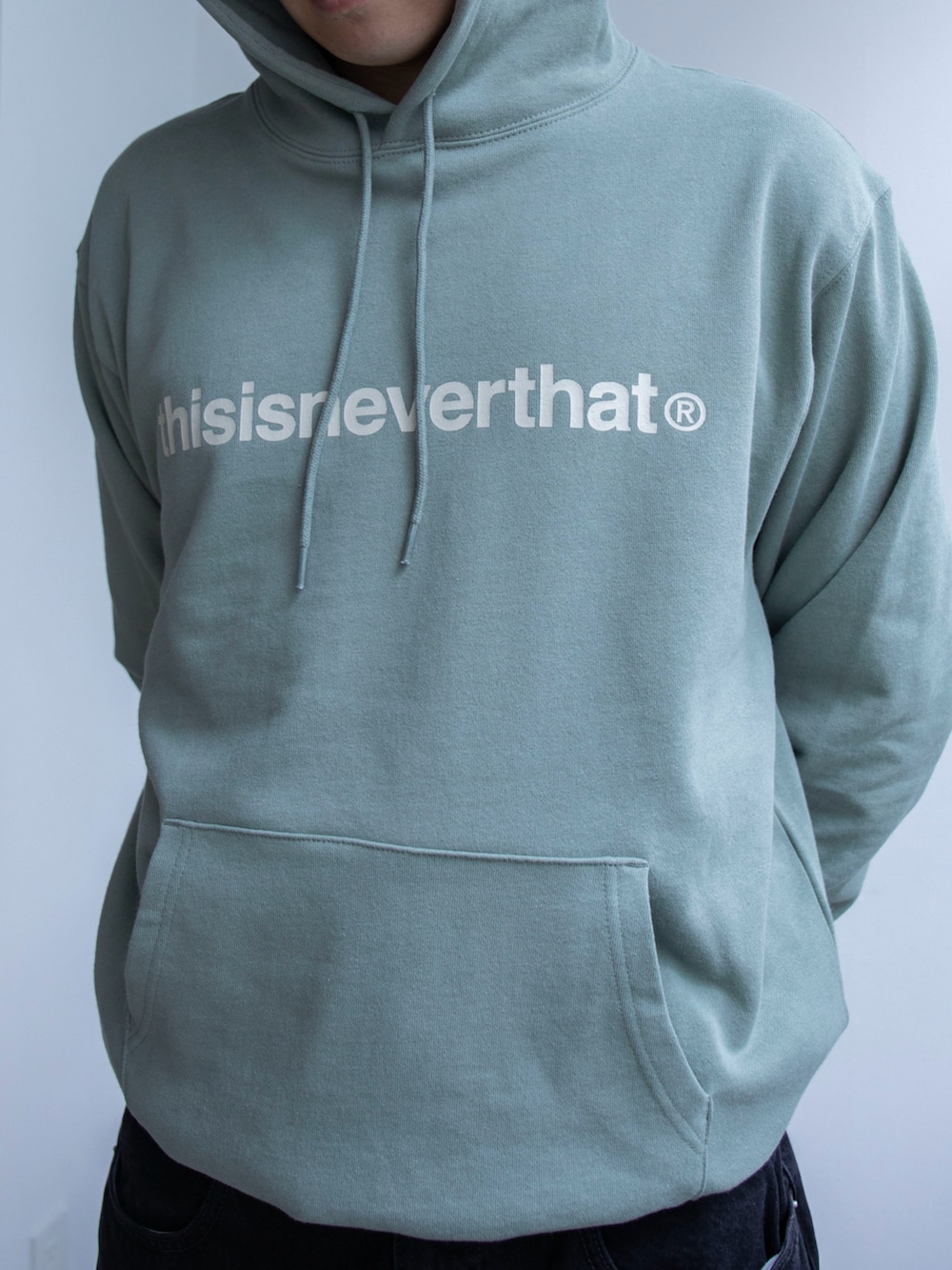 グリーン系のパーカー、ブラック系のデニムパンツを着用したメンズの春コーディネートの3枚目の写真